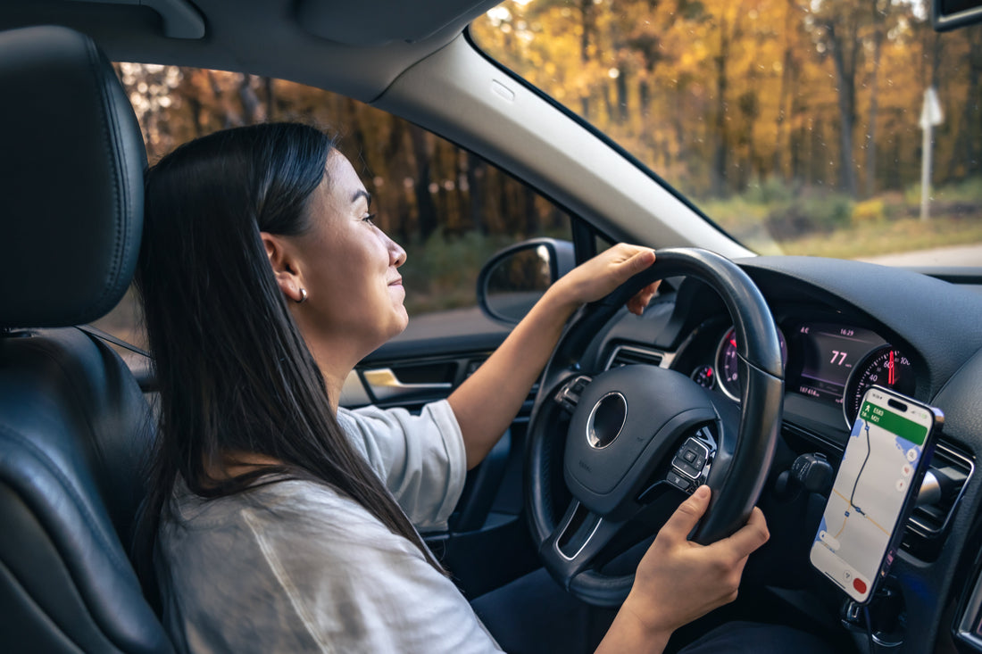 Driver enjoying a quiet car interior on a scenic road, illustrating improved cabin comfort with sound deadening installed
